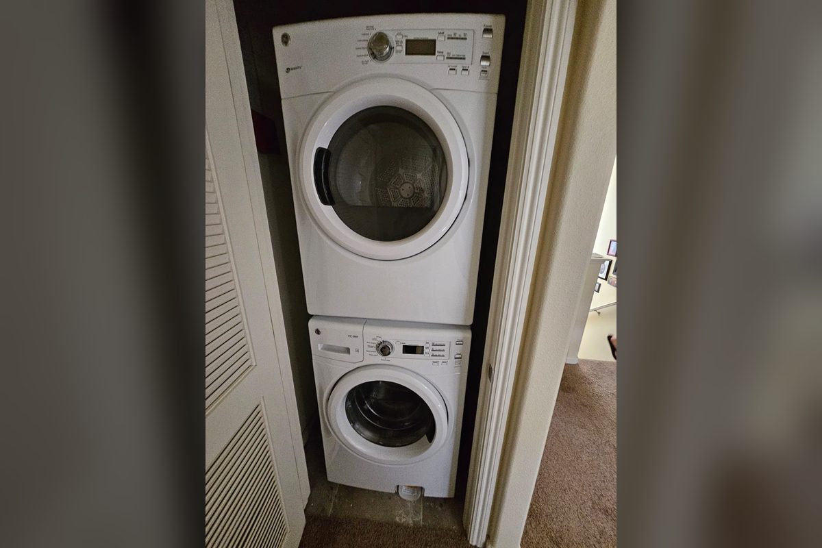 Stacked GE washer and dryer in a laundry closet serviced by Washer Repair Anaheim, CA